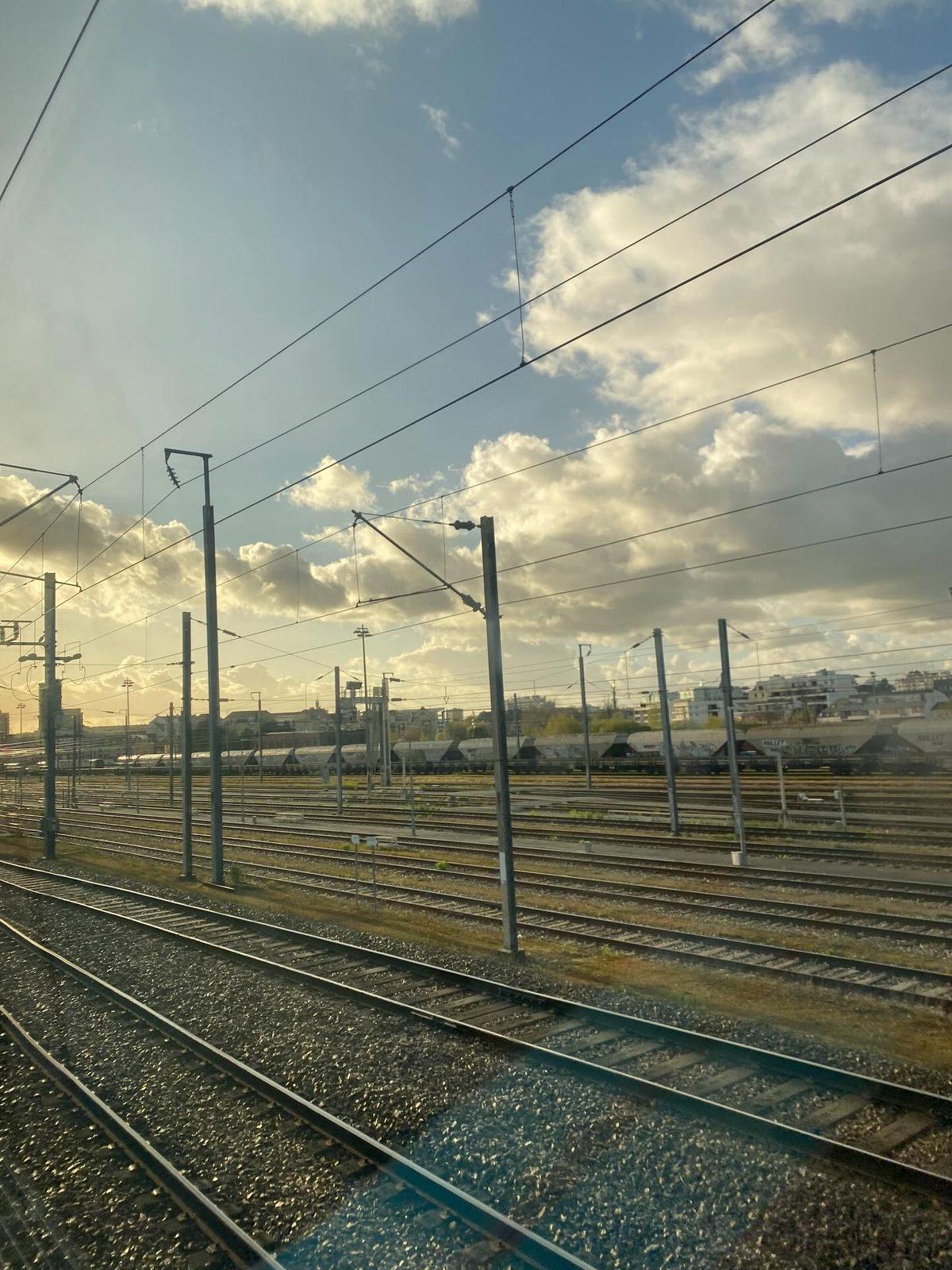 Railway tracks at sunset, seen from a train window leaving Rennes