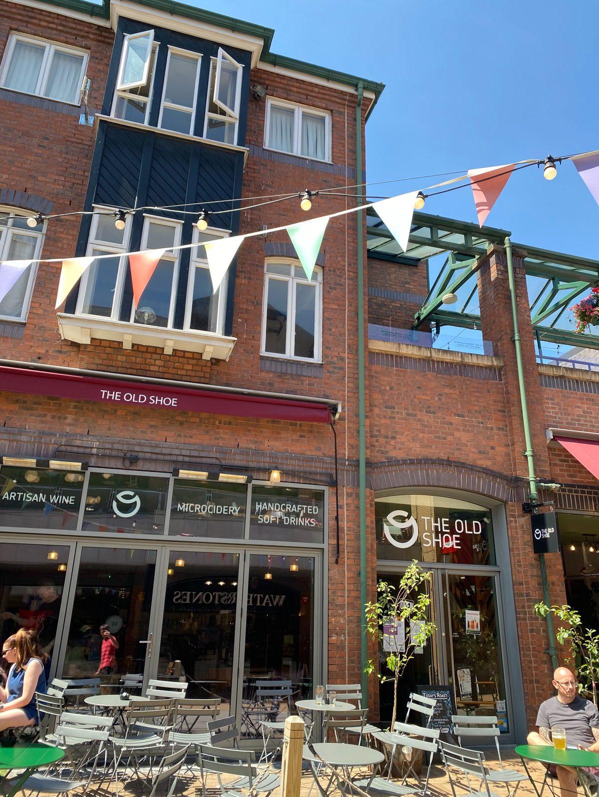 The red-brick exterior of The Old Shoe in Orchard Square, Sheffield, with bunting overhead and tables outside