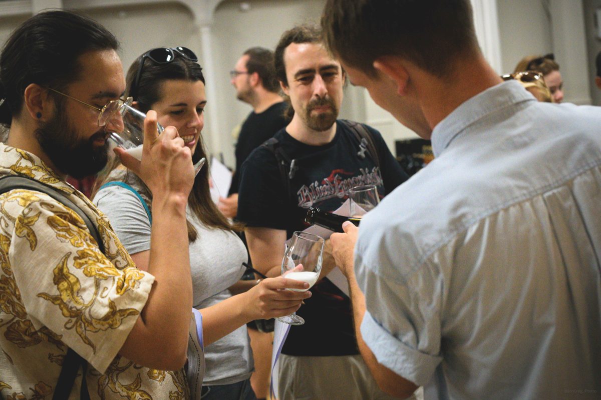 A group of tasters nosing their glasses as Jack pours at the Cidermugs table, Bristol Cider Salon
