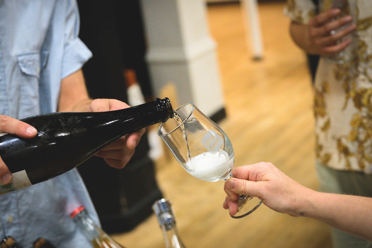 A close-up of Prémices being poured from a chilled bottle into a Cider Salon tasting glass