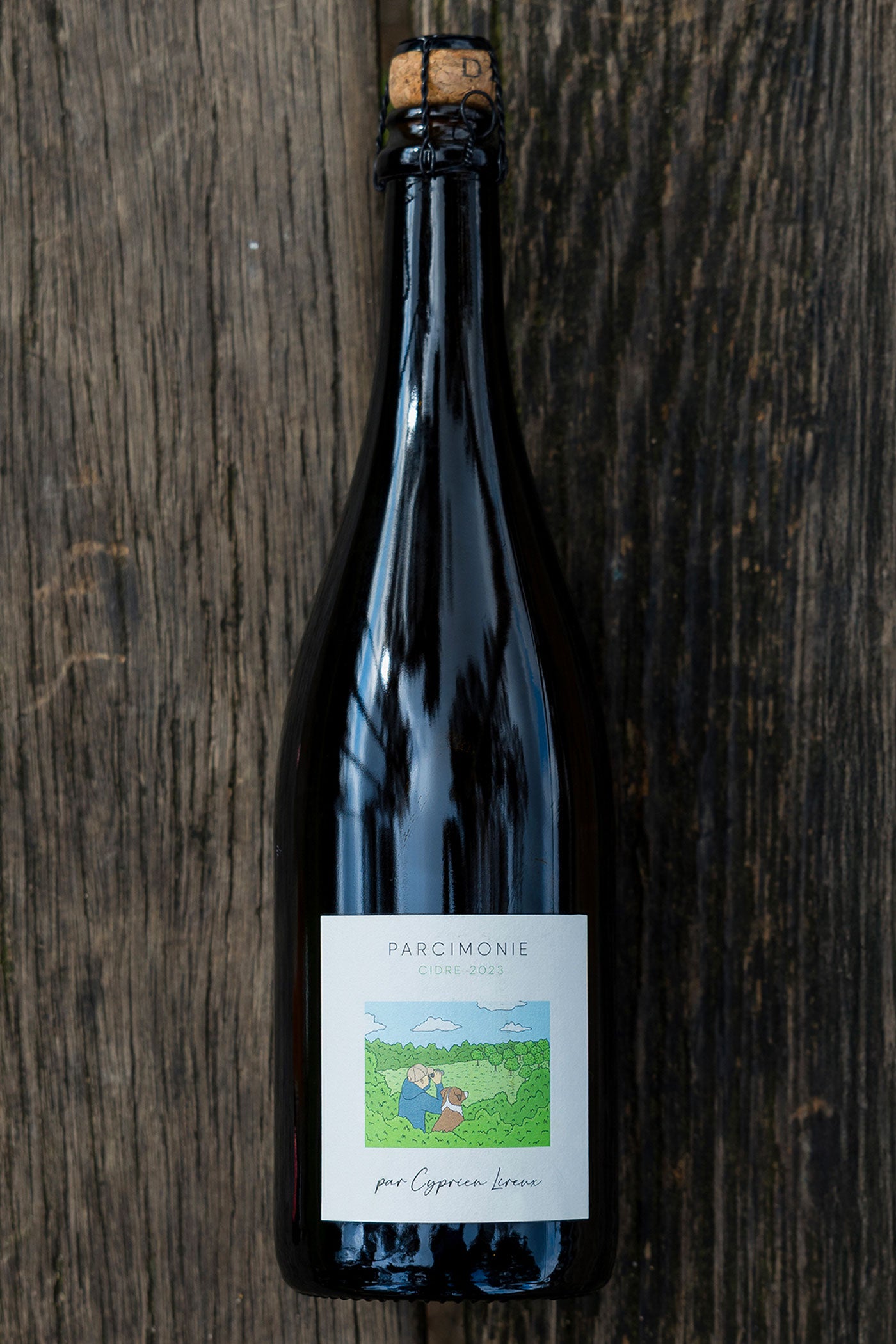 Parcimonie — bottle of Normandy-style brut cider on weathered wood